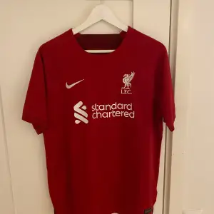 Liverpools hemmatröja säsongen 22/23. Replika tröja i jättefint skick. Knappt använd. 