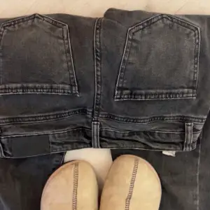 Lågmidgade jeans med en klippt slits på benen så de ser mer utsvänga ut på kroppen än på bilden.