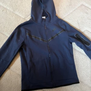 Nike tech tröja - Säljer en mörkblå Nike tech den är i bra skick skulle säga 8,5/10 använd några fåtal gånger. Den är köpt för 1200kr säljer nu för 400kr priset kan förhandlas vid snabb affär!🤝 hör av dig om du undrar nått mer