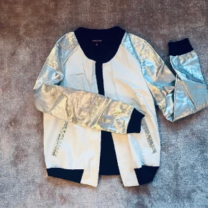 Space Silver  - En fin sweatshirt med dragkedja fram. Silver ärm, vitt fejkad skinn som behöver lite rening då ärmen har legat pressat därav det billiga priset 🌟🪐🚀