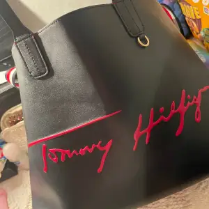 Tommy Hilfiger väska i mörkblå. Liten plånbok i insidan som gör att ta bort. 
