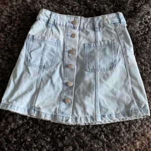 Jeans kjol  - Det är i bra skick, knappt använda. Man knäpper den hela vägen uppåt för att stänga den.