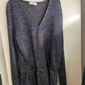 Svart glittrig blus från ellos st 34/36  - Säljer pågrund av att den inte kommer till användning. Väldigt bra skick! Storlek 34/36