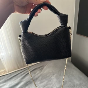 Svart handväska  - Liten svart handväska med guldkedja, perfekt för fest!❣️
