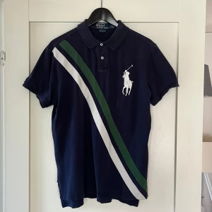 Pikétröja från Polo Ralph Lauren  - En mörkblå pikétröja från Polo Ralph Lauren. Relativt använd men i väldigt bra skick. Säljs typ inte längre. PRIS ÄR DISKUTERBART.