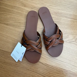 Tofflor Mango - Säljer dessa tofflor från mango i storlek 37, då de inte passade mig. De är i läder och helt oanvända (lappen sitter kvar)🌺💞 Nypris 529kr