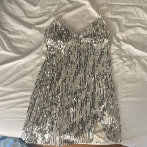Silvrig Paljettklänning  - Silveig paljettklänning från shein!! Aldrig använd, köpt för 299kr säljer för 199kr men kan tänka mig sänka priset i snabb affär