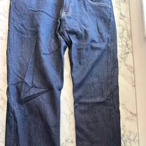 Ett par mörkblåa lee daren zip fly jeans i storleken 32/32 med passformen straight leg. Byxorna har endast använts ett par gången och ser ut precis som ett nytt par. Hur man tvättar byxan står på en lapp inuti byxans övre del. Kan mötas upp vart som