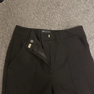 Kostymbyxor flare leg/bootcut - Helt nya kostymbyxor med lite flare leg och en söm som fin extra detalj. Detalj ficka på baksidan (ej riktig ficka)  (Oanvända)  Innreben: 77cm Ytterberg: 105