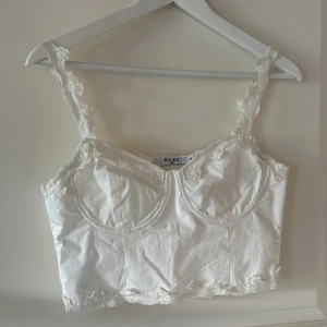 Vit topp - Kort topp med fina detaljer, dragkedja i sidan. Endast använd en gång, nyskick🤍