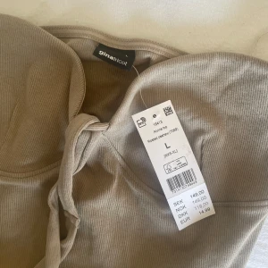 beige topp med snören - aldrig använd, normal i storlek, sitter som en M, köpt för 149 
