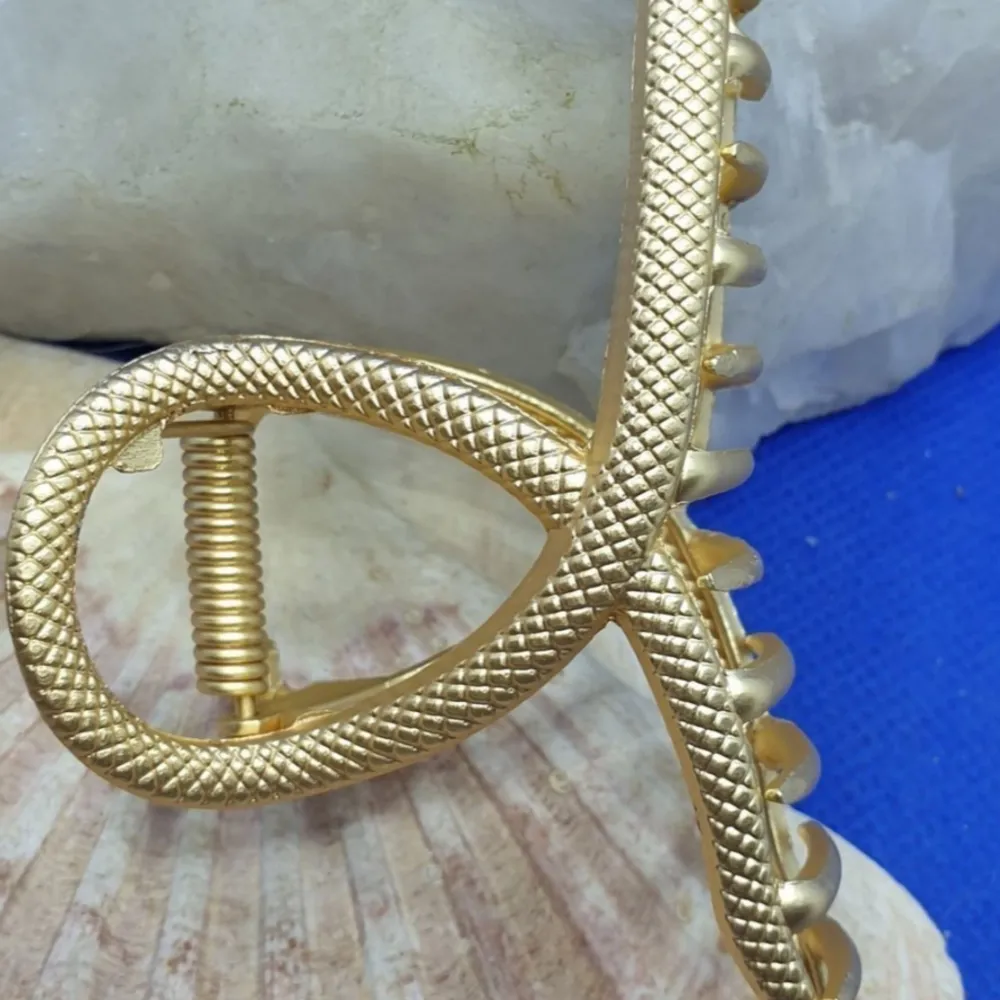 En snyggt designad Hårklämma storlek ca 11.5x6x3 Matt Guldfärgad metall med snygg utformning på själva klämman, innehar formen av en orm.. Accessoarer.