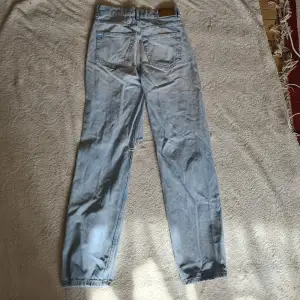 Ljusblå straight jeans med hål på knäna från gina tricot i storleken 32. Byxorna har en liten fläck. Men fortfarande snygga.