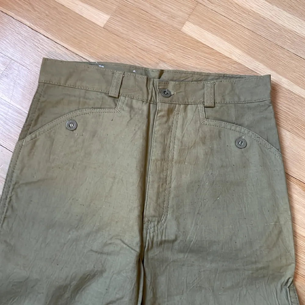 Vintage utsvängda byxor från Dobber, grönbeige färg. Helt nya med lapp kvar, endast legat på lager. Märkta size 28, inseam 36.  Mått cm: Midja: 33 Höft: 41,5 Ben: 90  . Jeans & Byxor.