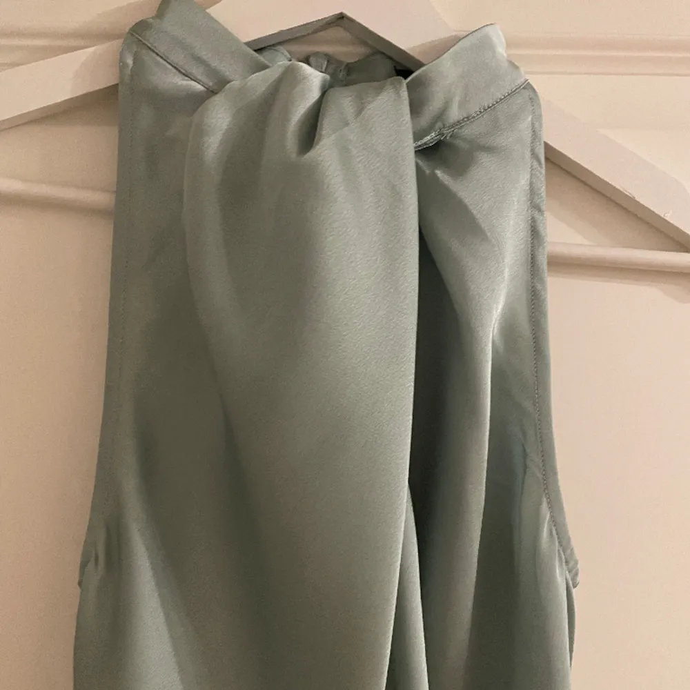En grön klänning i satin i storlek 36. Sitter väldigt fint på. Har en slits på ena sidan samt knappar. Endast använd 1 gång. Klänningar.