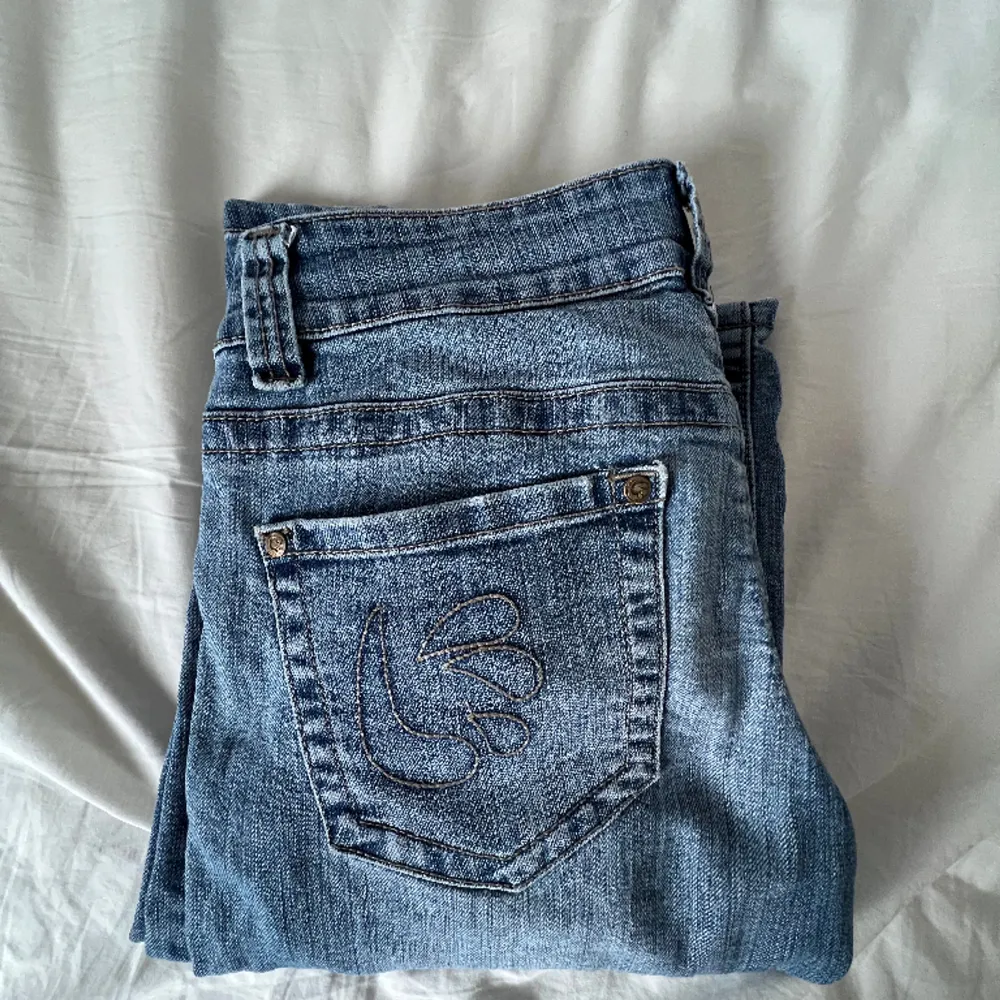 Säljer blåa jeans, köpts på second hand. De är i utsvänga/vida och lågmidjade. De har inga defekter men har insytt band vid midjan (se bild 3)❤️ Kontakta för bilder eller frågor🩷. Jeans & Byxor.