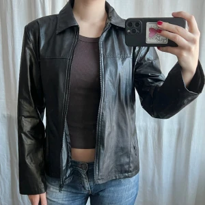 Svart skinnjacka - Svart vintage skinnjacka i skinnimitation från Cricket. Har lite defekter vid ärmarna men inget som syns 💕Skriv privat för bilder! Unisex fit