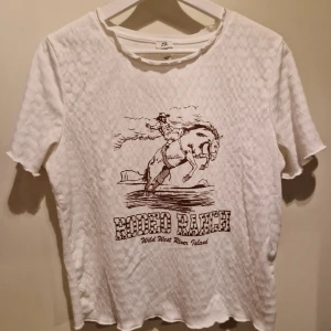 Vit tshirt med tryck  - Vid t-shirt med brunt tryck och paljetter från river island  Storlek 14, passar M 