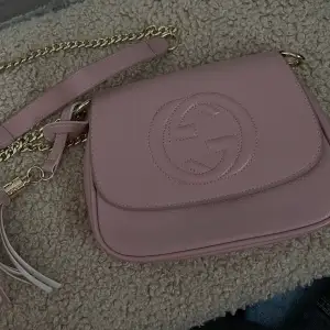 En supersöt och gullig rosa väska med guldiga detaljer 