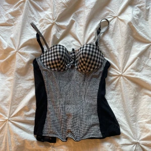  korsett topp - Säljer denna korsett topp från topshop.  jag köpte här på plick men den va för liten vid min byst. Skulle säga att den passar A kupa eller liten B kupa. Jätte fin och snygg, antingen till vardags eller fest.