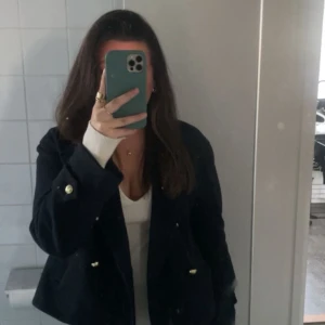 Marinblå kappa med guld knappar  - En jätte fin marinblå kappa med guld knappar. Är i super fint skick med tanke på att den endast är använd 1 gång. Passar perfekt nu till våren!  Köptes för 600 kr. 