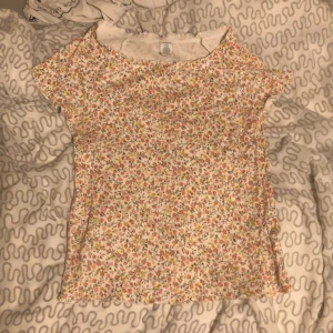 Somrig topp - Perfekt skick, T-shirt med blommor på. Barnstorlek men den är i stretchigt tyg så passar xs/s tror ja. 