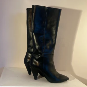 Knähöga boots, modell Myrassa 7556  - Knähöga boots i modell Myrassa 7556 från märket Samsøe Samsøe  Storlek 39 Överdel i äkta läder Den är en knähög modell med spetsig tå Klacken är trekantig  Använd fåtal gånger, Fint skick Nypris 4000 Säljs pga kommer ej till användning
