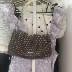 Zadig & Voltaire Väska Rock Clutch - Så snygg Zadig Clutch som jag tyvärr behöver sälja pga att den inte kommer till användning. Tecken på användning men i bra skick. Kedjan har tappat lite färg. Dustbag medföljer. Den är grå/oliv. 