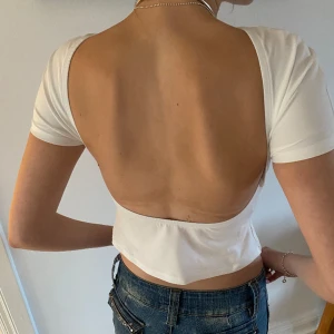 Öppen rygg t-shirt - Denna topp är otroligt snygg. Den är köpt i en affär i Barcelona. Passar nog både S och M beroende på hur tajt man vill ha den. 