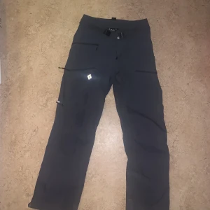 Skalskidbyxor - Fina,sköna outdoorbyxor man kan ha till tex vandring, skidåkning. Grovt material längst ned för skydd mot pjäxan.  Lite slitna längst ned men inget man tänker på. Annars helt felfria. 4 fickor fram. Inköpspris: 2000kr i alperna. 