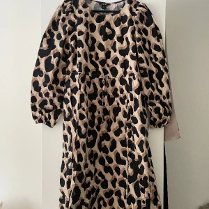 Leopardklänning - Leopardklänning från monki i storlek xs använd 3 gånger. Skulle säga att den passar xxs-s beroende hur tight/lös man vill ha den, finns så man kan knyta i midjan