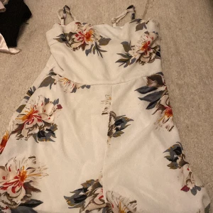 En byxdräkt  - Säljer en byxdräkt till sommaren/midsommar. Blommor och vitt. 