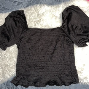 Svart topp - Svart topp med puffärmar Storlek: M Säljes för 10kr+fraktpris