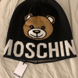 MOSCHINO MÖSSA - Jag säljer min moschino mössa då den ej kommer till användning den är slutsåld överallt. Jag köpte den av en tjej här på plick men den var helt ny och jag har haft den i ungefär 2 veckor. Kontakta mig för frågor💕💕