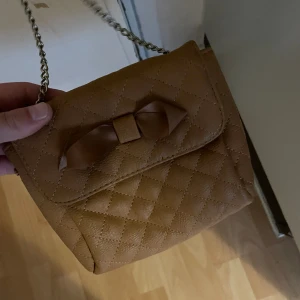 Brun väska  - En liten söt brun väska, helt okej skick inte helt ny, kontakta mig innan köp!