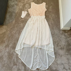 Klänning  - Finklänning som har fina blommor på framsidan av över kroppen, på baksidan är det en dragkedja. Kommer med ett band som man kan ha runt midjan🩷