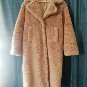 Kappa från Gina Tricot i teddy - Varm och mjuk kappa i oversize perfekt till höst och vinter. Camel/beige färg med fickor. Denna fryser man inte i.
