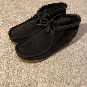 Clarks Wallabee High - Mycket snygga och stiliga Clarks i modellen Wallabee! De är varsamt använda och är i väldigt bra skick. Storlek 43. Nypris: 2000, Mitt pris: 599. DM vid frågor eller fler bilder! 