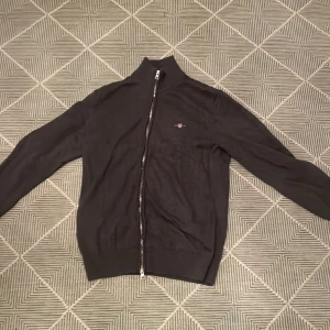 Gant full-zip  - Säljer nu min gant zip tröja pga att jag varken använder den eller har de. Kanske har använt den 1-2 gånger men annars har den bara legat i mitt rum. Skick 10/10 inga slitage. 