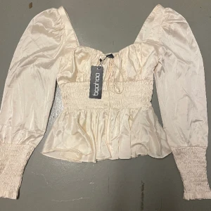 Blus - Oanvänd blus från Boohoo i skimrig ljusbeige/rosa färg! (Bilderna ger rättvisa till färgen) super fin men inte kommit till användning 
