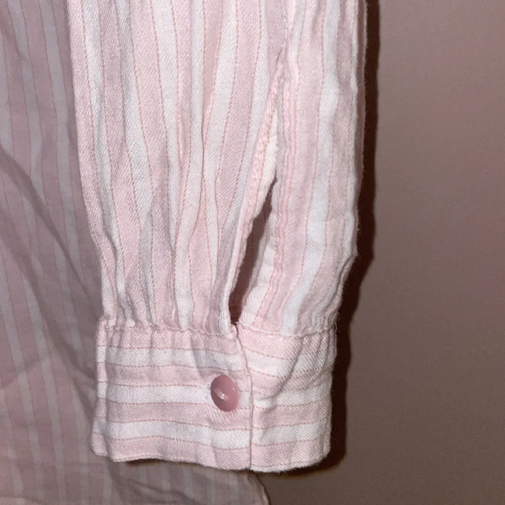 En randig vit rosa skjorta😍 Materialet är supermysigt och fickan är riktig💕 Kort i armarna och lång i modellen.. Skjortor.