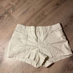 Ett par beige/ cremevita lågmidjade cargoaktiga shorts i storlek S (36) från H&M. Knappt använda(: