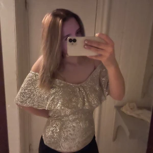 glittrig topp - glittrig off shoulder topp, kostar 600kr nypris och är från märket ichi. Köpt på Åhlens. Aldrig använd och lapprna sitter på. Storlek S. Snygg till nyår eller på fest!! Skriv om ni har fler frågor❤️