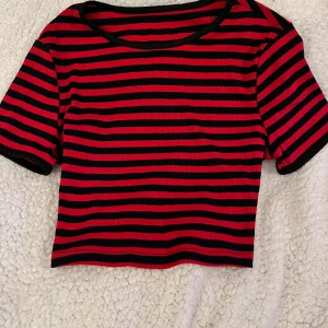 Trendig randig kort tröja - Den perfekta tröjan för både fest och vardag. Randig mindre modell. Mörblå och hallonröd/ mörkröd.  Snygg. 