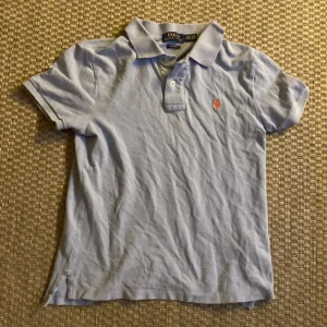 Ljusblå Ralph lauren piké - Ljusblå Ralph lauren pike märkt stl:14-16 men motsvarar ungefär 158-164.