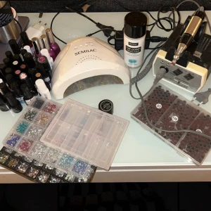 Nagel grejer - Nagel grejer, gellacken knappt använda. Allt fungerar felfritt. Medföljer bla elfil & fil bits, lampa från semilac, nagel prep, matt & glansigt top coat, base coat, olika gellack, nagelstenar samt lim till, tippar, nagel sax, filar mm. Finns i gbg.