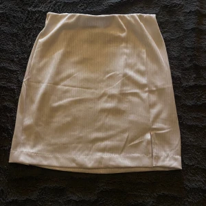 mini kjol - vit mini kjol med en liten slits i strl xs helt oanvänd 