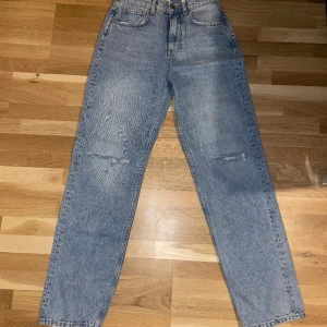 Jeans - Ljusblåa raka jeans med hål i knäna  Aldrig använda dom.