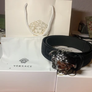 Versace Bälte - Ett snyggt versace bälte (110 cm) som inte används längre. Bältet är ny skick och det finns inga fel på det. Box medföljer 