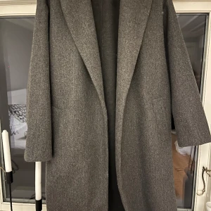 Lång kappa - Lång kappa från vero moda. Aldrig använd. Mörkgrå färg. Storlek M.